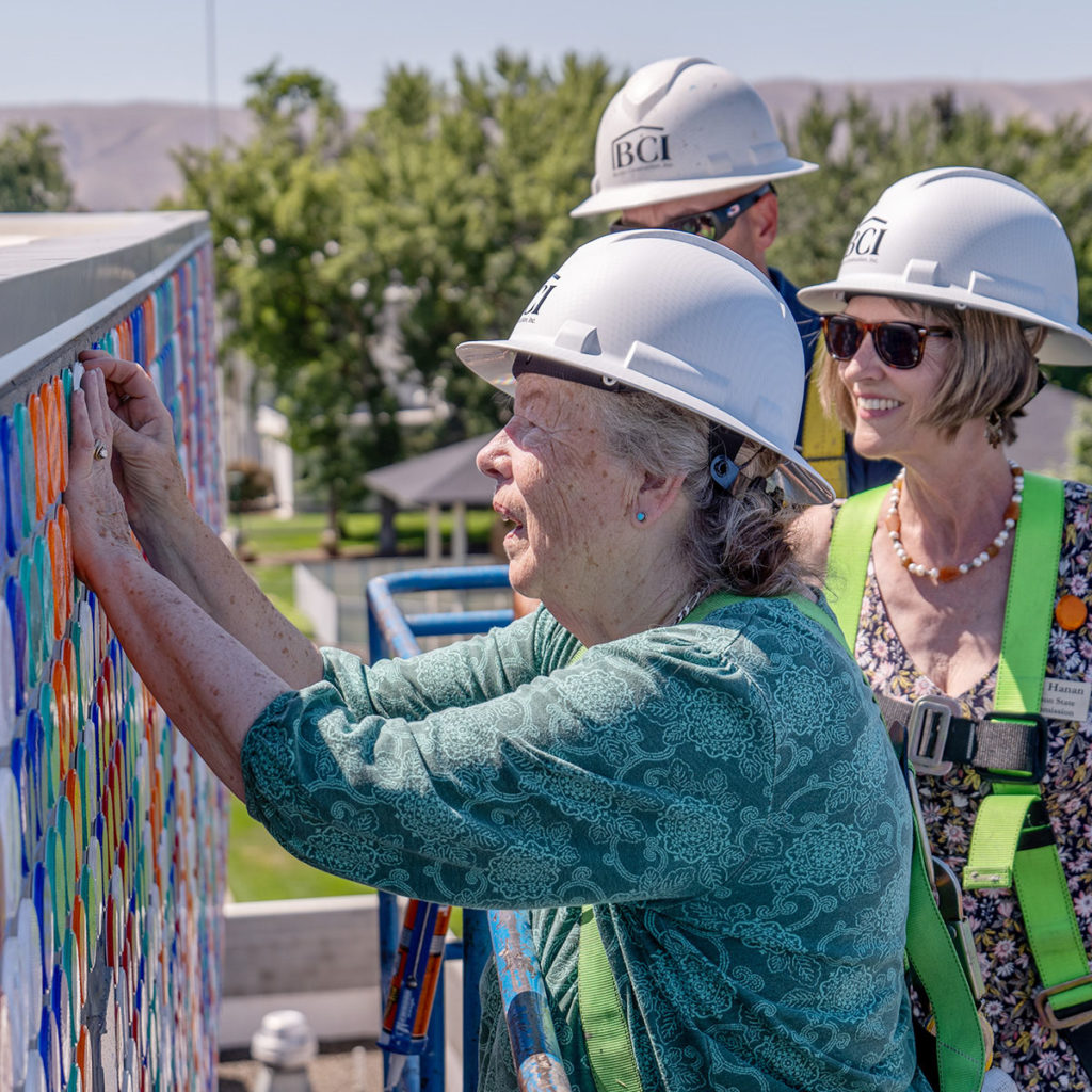 Jane Orleman, wife of the late Dick Elliott, places the final reflector in "Circle of Light."